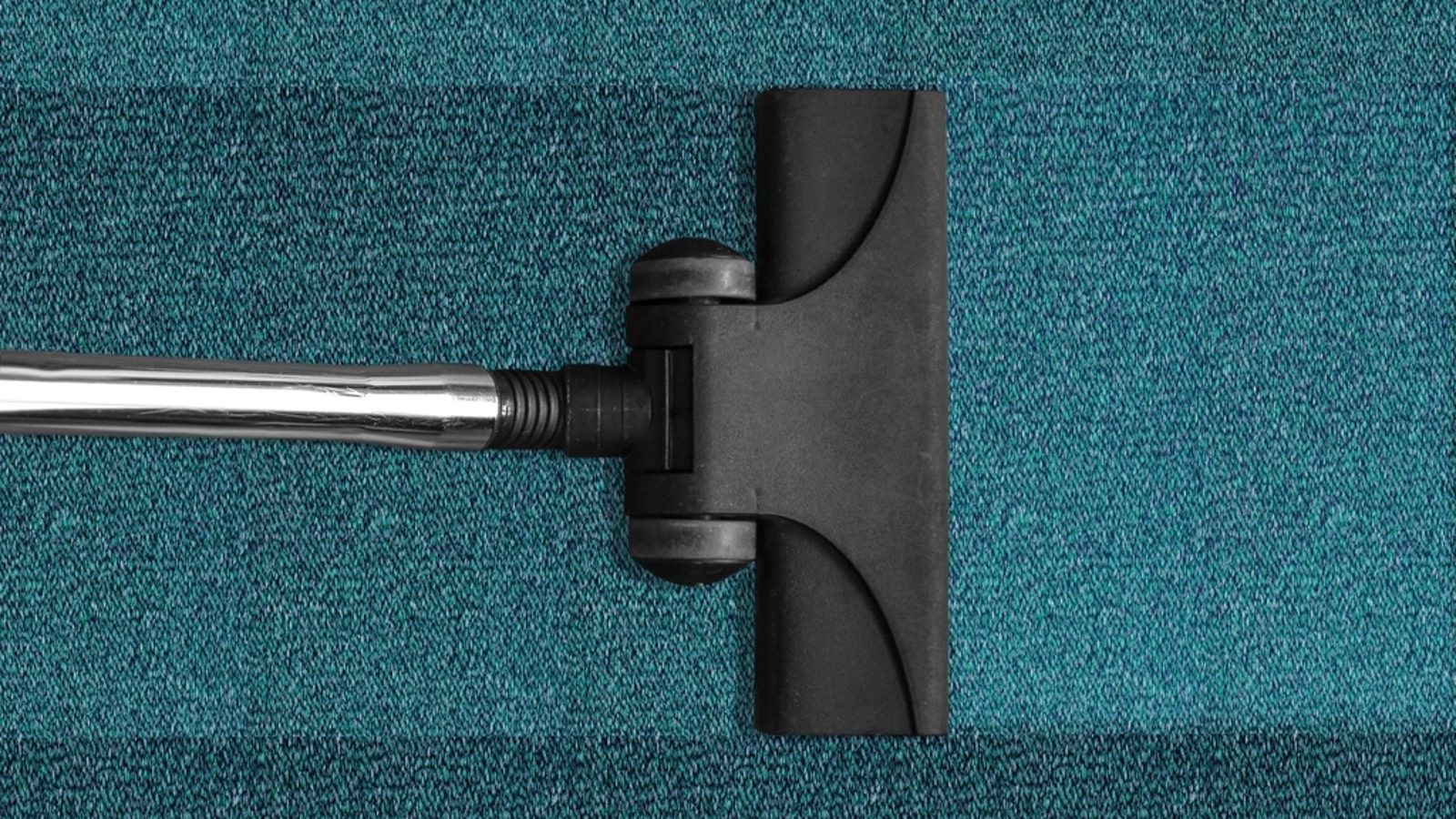 Tete d'aspirateur sur tapis turquoise